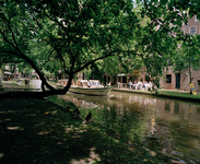 822503 Gezicht over de Oudegracht te Utrecht tussen de Viebrug en de Jacobibrug (op de achtergrond); op de gracht vaart ...